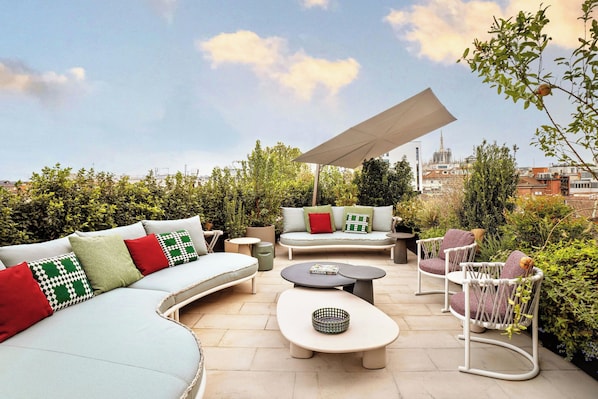An outdoor patio with a sofa, chairs, and a table.