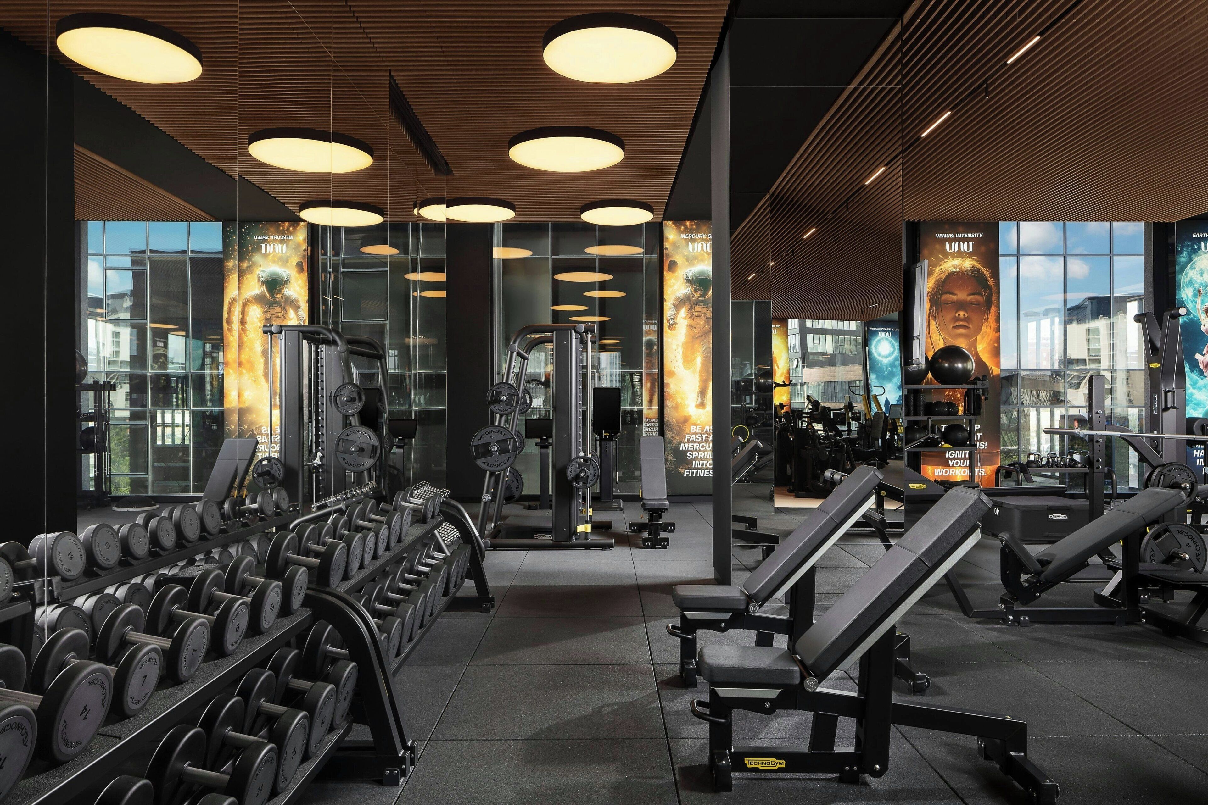 A gym with various exercise equipment, including dumbbells, benches, and weight machines.