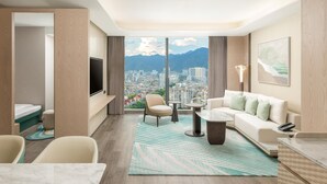 A modern hotel room with a city view, a sofa, a dining table, and a TV. - Lishui Marriott Hotel (Lishui)