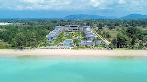 Un complexe hôtelier comprenant plusieurs bâtiments, un espace piscine et une plage.