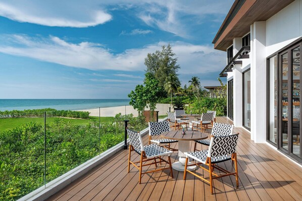 A deck with outdoor furniture overlooking a beach and ocean. - Khao Lak Marriott Beach Resort & Spa (Takua Pa)