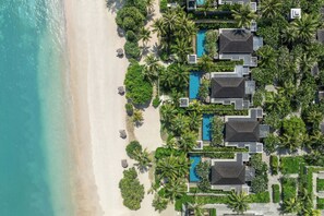 An aerial view of a beachfront resort with multiple villas, a swimming pool, and lush greenery. - The Sira, A Luxury Collection Resort And Spa, Lombok (Tanjung)