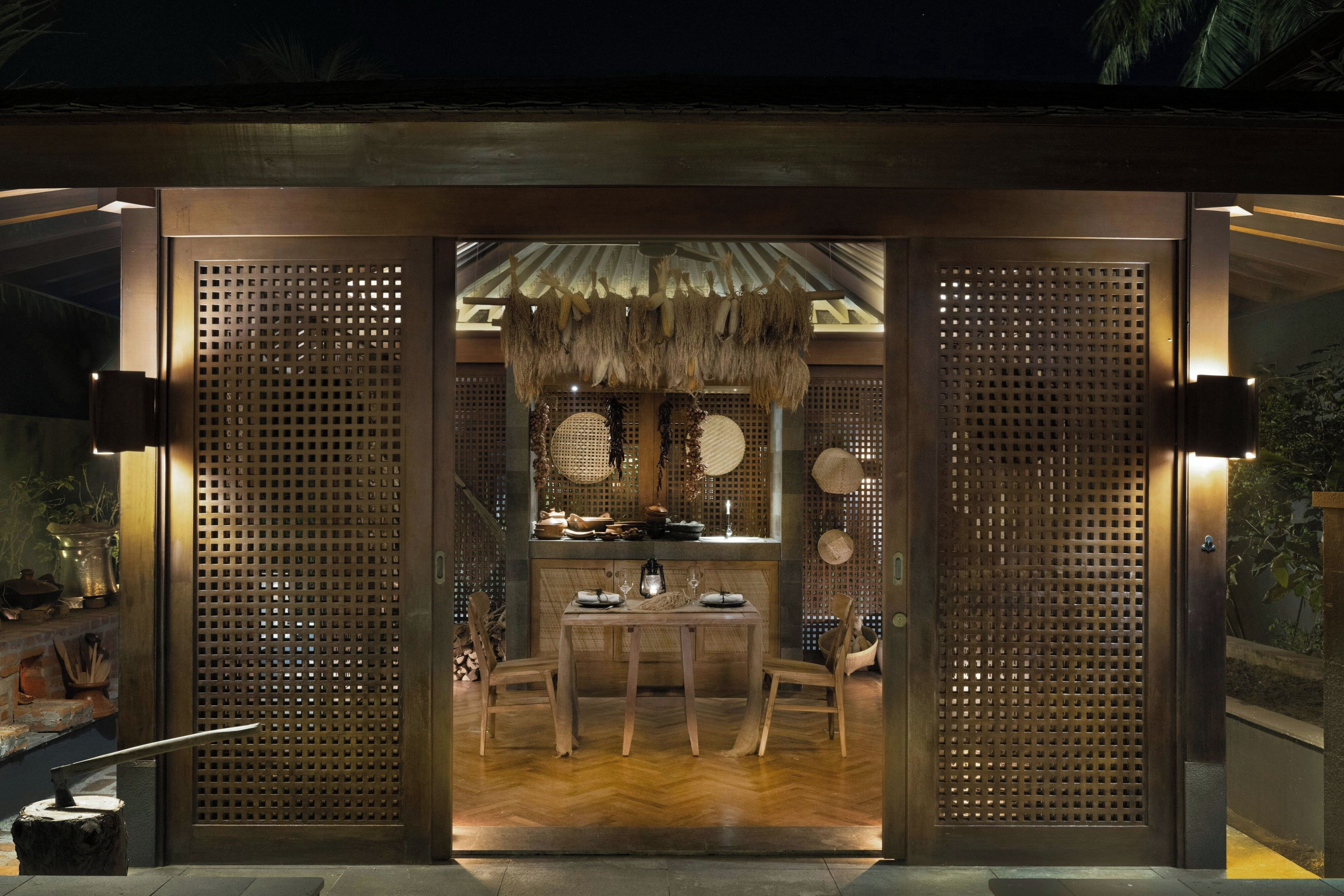 A traditional Japanese-style interior with tatami flooring, a low table, and a hanging corn display.