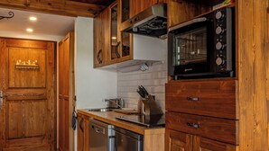 Een keuken met houten kastjes, een roestvrijstalen vaatwasser en een inbouwoven.