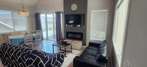 Een smart-tv, een open haard, boeken en een stereo