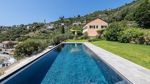 A rectangular swimming pool with a clear blue water surface, surrounded by a concrete deck.
