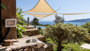 A stone pathway leading to a shaded outdoor area with a view of the sea. - VILLA DUFOUR 2 - Luxury, Swimming Pool, and Dream View (Zoagli)