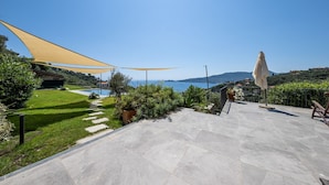 A patio with stone flooring, a yellow shade sail, and a view of the sea. - VILLA DUFOUR 2 - Luxury, Swimming Pool, and Dream View (Zoagli)