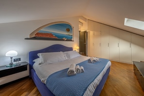 Un dormitorio con cama, mesita de noche, un cuadro y armario.