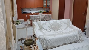 Un dormitorio con cama, una mesa de comedor con sillas, una zona de cocina y un baño.