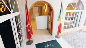 Een hotelingang met een receptiebalie, een wachtruimte en een uitzicht op het interieur.