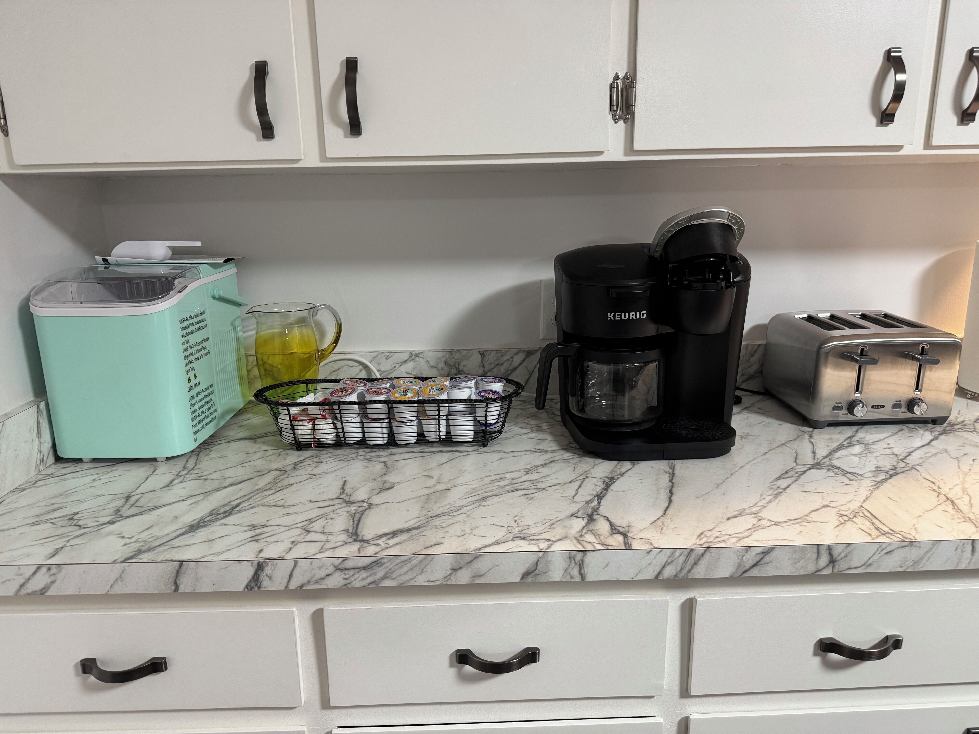 Eine Küchenarbeitsplatte mit Kaffeemaschine, Toaster und einer Kapselbehälter für Kaffee.