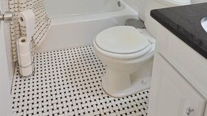 Ein Badezimmer mit Dusche, Toilette und Waschbecken.