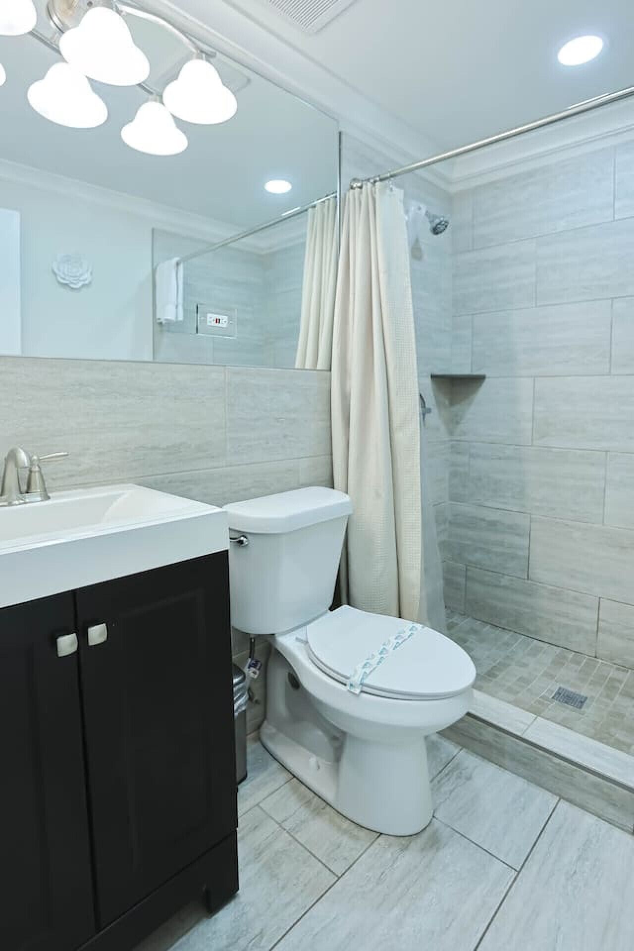 A modern bathroom with a shower, toilet, and sink.