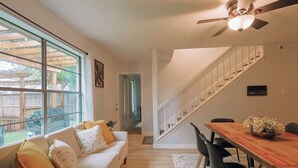 Una sala de estar con un sofá, una mesa de comedor y una escalera.