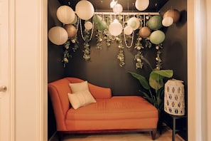 A room with a sofa, a decorative wall, and a hanging light fixture.