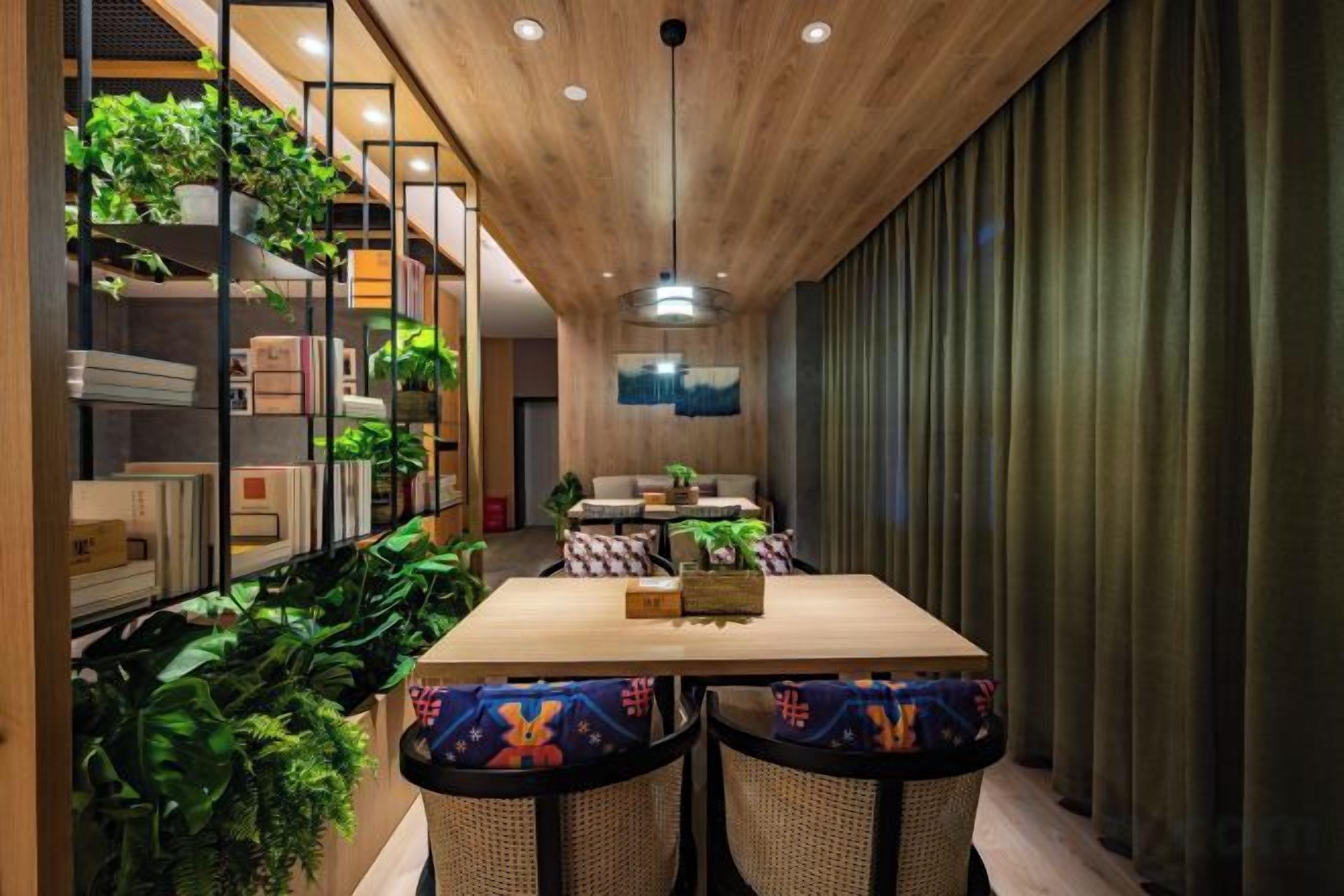 Un comedor con techo de madera, una mesa larga y sillas con cojines de colores.