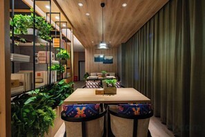 A dining area with a wooden ceiling, a long table, and chairs with colorful cushions. - TRUE GO Hotel (Zhengzhou ITC 360 Plaza Grand Emporium) (Zhengzhou)