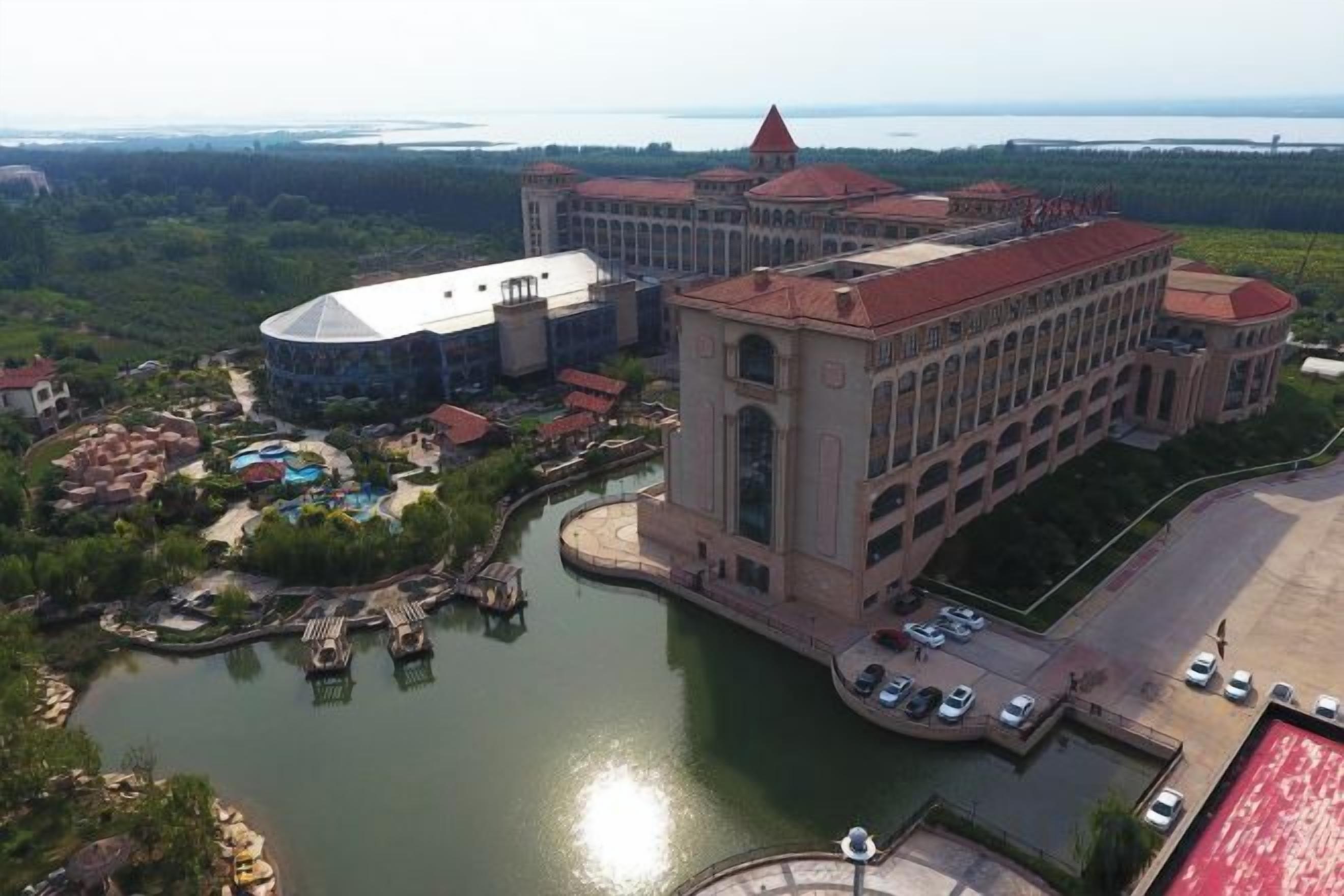 A large hotel with a central building, a waterfront, and a small island with docks.