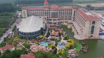 A large hotel with a central courtyard, multiple wings, and a body of water.