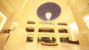 A spacious lobby with a central fountain, multiple levels of balconies, and a large circular skylight. - Hengshui Taihua Boyue Hotel (Hengshui)