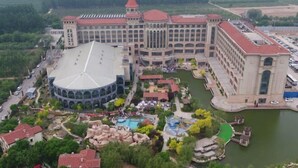 A large hotel with a central courtyard, multiple swimming pools, and a lake. - Hengshui Taihua Boyue Hotel (Hengshui)