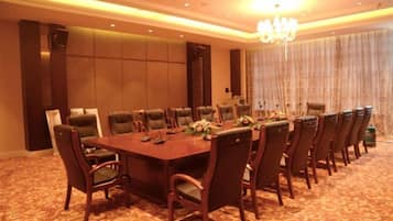 A conference room with a long table, chairs, and a chandelier.
