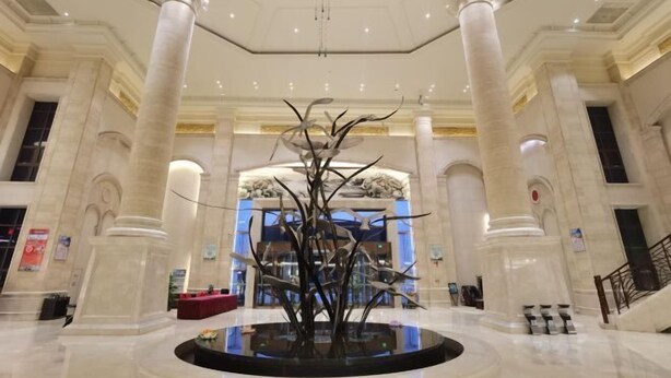 A grand lobby with a central sculpture, marble columns, and a staircase. - Hengshui Taihua Boyue Hotel (Hengshui)