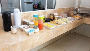 Un mostrador de buffet con diversos alimentos y salsas.