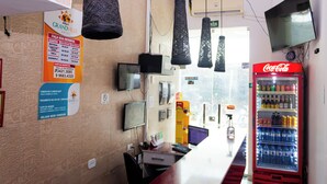 Zona de recepción de hotel con una máquina expendedora de Coca-Cola, una computadora y un letrero.