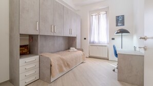 Une chambre à coucher avec un lit, une armoire, un bureau et une chaise.