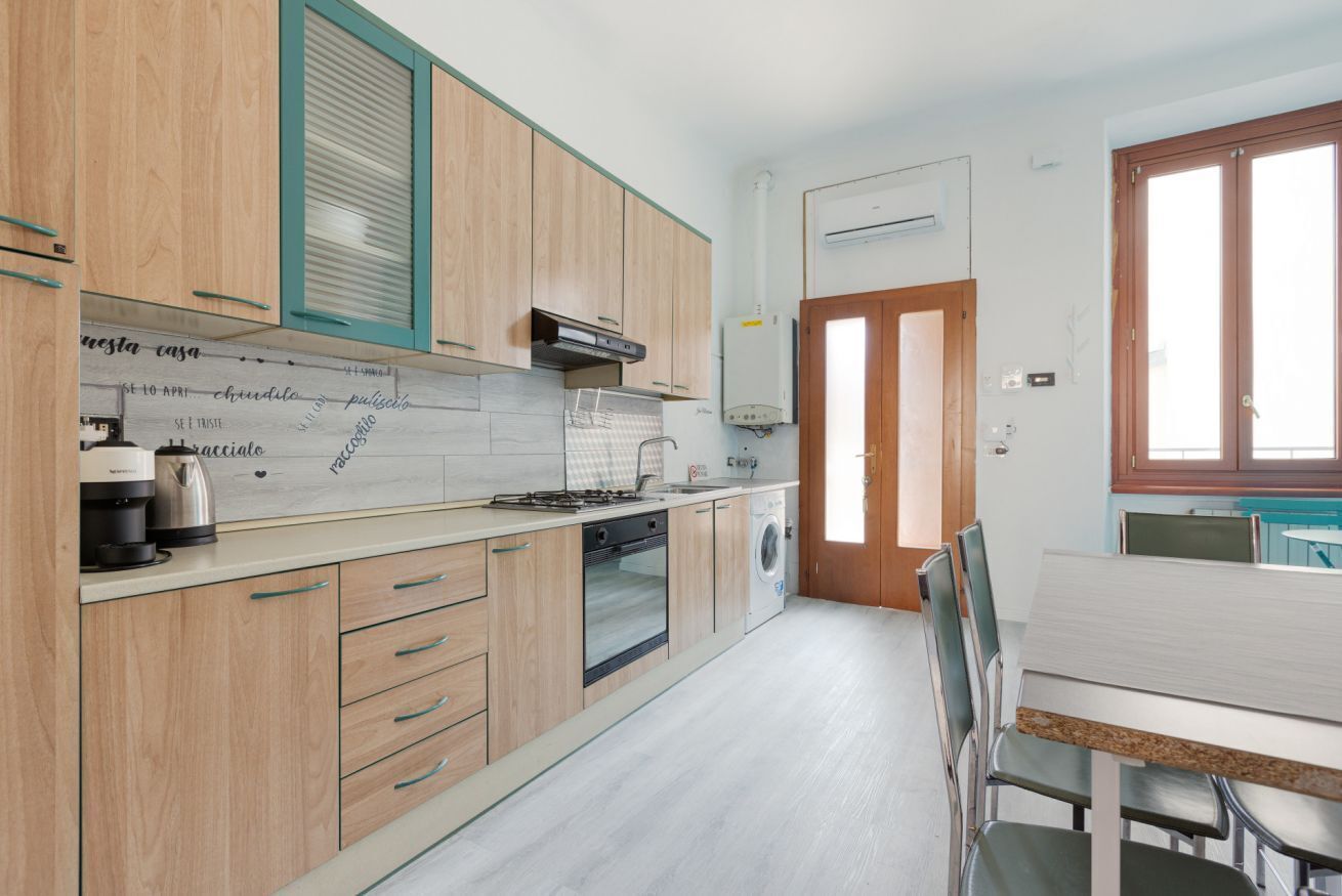 Eine moderne Küche mit Holzausstattung, Backofen, Geschirrspüler und Spüle.