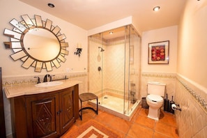 A bathroom with a round mirror, a sink, a toilet, and a shower enclosure. - Casa Sérénité San Miguel (San Miguel de Allende)