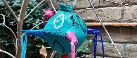 A hanging decoration with a blue and pink color scheme, attached to a branch.