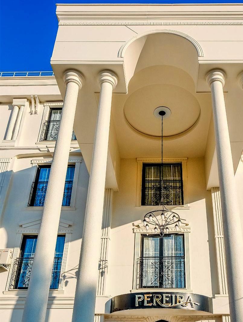 A building with classical architecture, featuring columns and a prominent entrance with the name 'PEREIRA'.