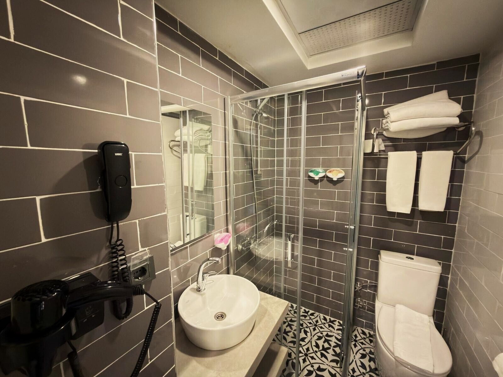 Une salle de bain moderne avec une douche à parois de verre, un lavabo et des toilettes.