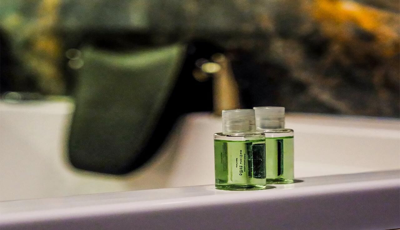 Two small bottles of hand sanitizer on a bathroom sink.