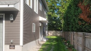 A two-story house with a well-maintained lawn and a wooden fence.