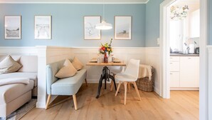 A dining area with a table, chairs, and a vase of flowers.