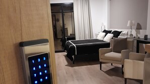 Une chambre d’hôtel équipée d’une serrure électronique, d’un lit, d’un canapé et d’un bureau avec une lampe.