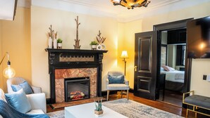 A living room with a fireplace, a sofa, a coffee table, and a chair.