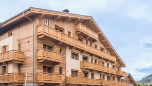 Un immeuble en bois à plusieurs étages, doté de balcons et de fenêtres.