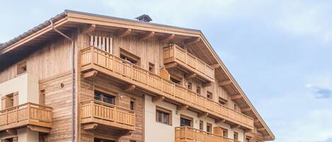 A multi-story wooden building with balconies and windows.