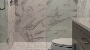 A bathroom with a shower, toilet, and vanity.
