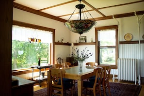 A dining area with a wooden table, chairs, and a chandelier. - Harbor Hill House Bayfield, WI (Bayfield)
