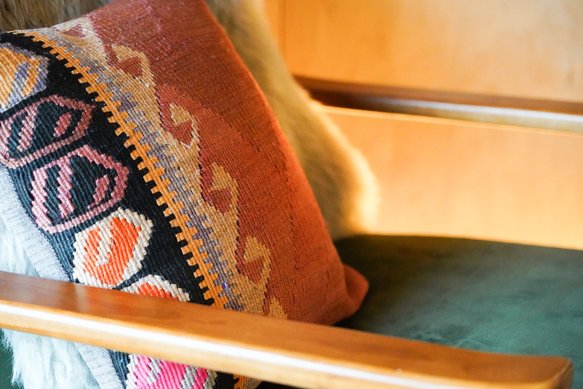 Una silla de madera con un cojín estampado y colorido.