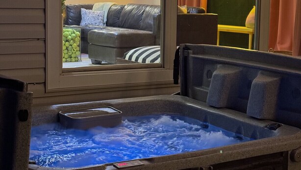 Un bain à remous donnant sur un salon par une fenêtre.
