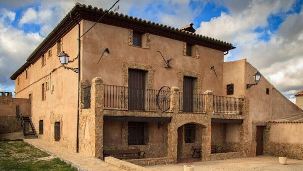 Un edificio histórico con un patio, paredes de piedra y balcones tradicionales.
