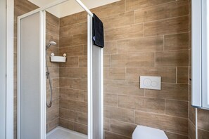 A shower with a handheld showerhead, a white toilet, and a wall-mounted towel rack. - Apartment 'Blue Water' with Air Conditioning (Porto Valtravaglia)