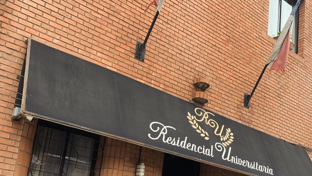 Un edificio de ladrillo con toldo negro que muestra el texto 